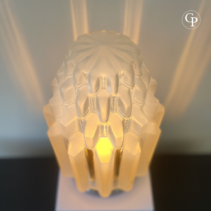 Top view of illuminated Art Deco Skyscraper table lamp with frosted sculpted glass shade casting warm ambient light and geometric reflections | Vue supérieure de la lampe de table Art Déco Skyscraper allumée avec abat-jour sculpté en verre dépoli diffusant une lumière chaleureuse et des reflets géométriques