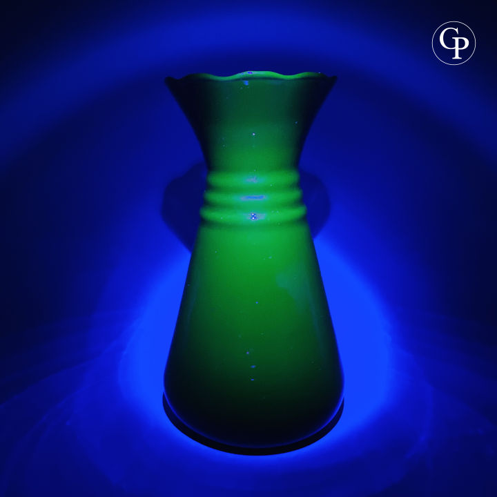 Vue du vase Art Déco en verre hyalite révélant une intense luminescence verte sourde sous lumière noire (UV), témoignant de la présence de manganèse dans sa composition, Galerie Popincourt | View of the Art Deco hyalite glass vase revealing intense dull green luminescence under blacklight (UV), indicating manganese content in its composition, Galerie Popincourt