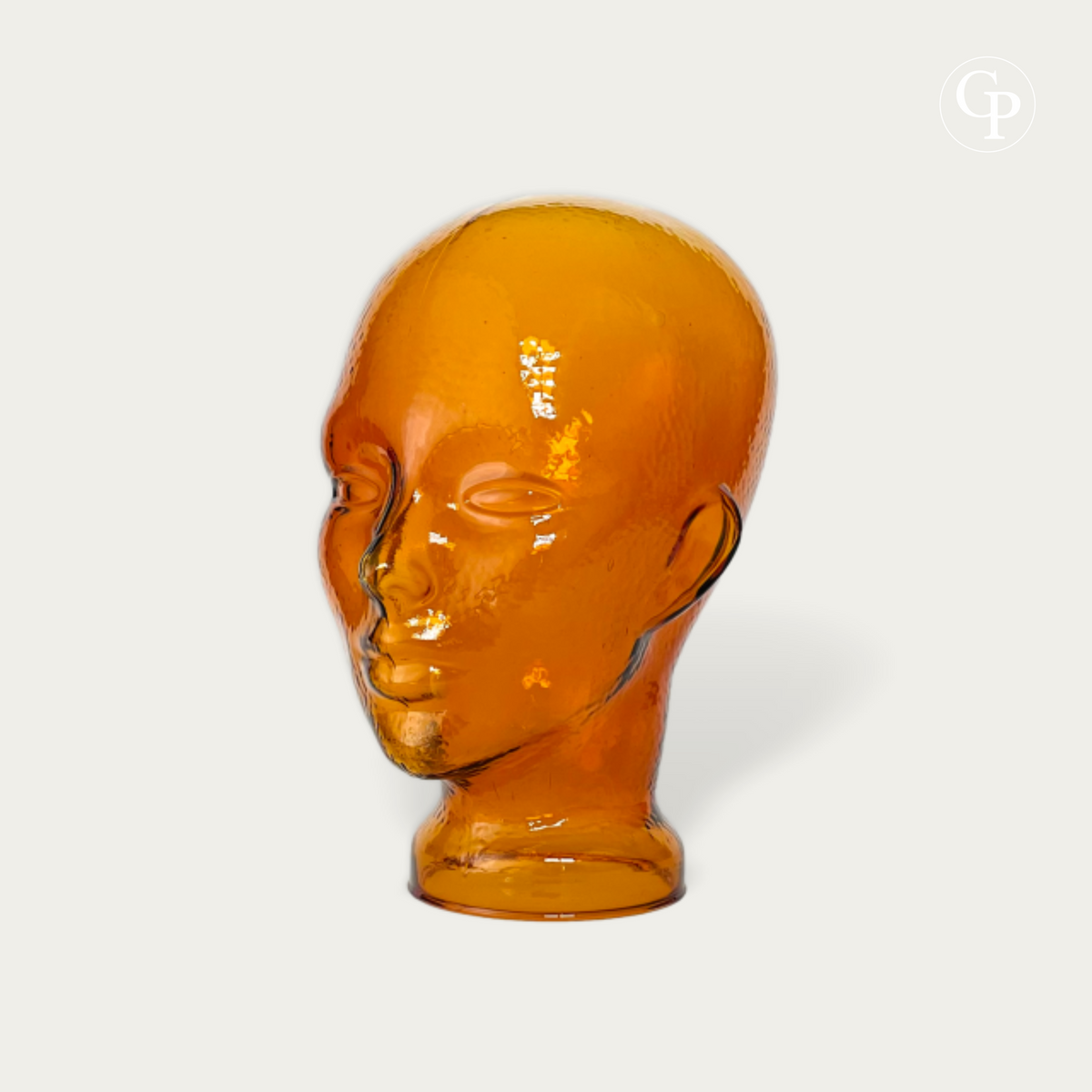 Tête mannequin vintage en verre moulé ambre cognac style Space Age 1970 vue de trois-quarts sur fond neutre | Vintage 1970s Space Age amber cognac molded glass mannequin head