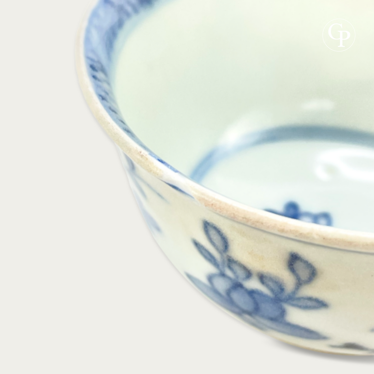 Gros plan sur le bord de la tasse porcelaine Ca Mau avec marque de mer authentique | Close-up of the rim of the Ca Mau shipwreck porcelain cup showing authentic marine wear