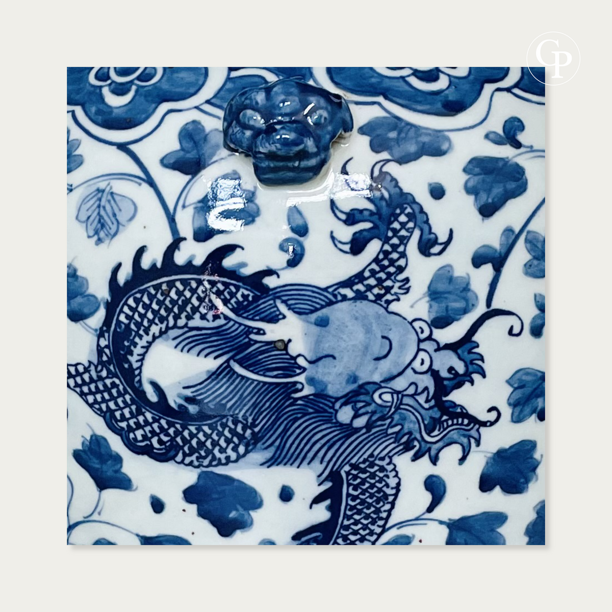 Gros plan sur le décor peint de la tête de dragon impérial et la mascarode de lion gardien appliquée en relief sur la porcelaine bleu et blanc du XIXe siècle | Close-up of hand-painted imperial dragon head and relief guardian lion mask on 19th century blue and white porcelain