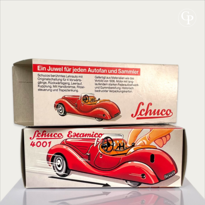 Alternative view of the original vintage box and illustrated sleeve for the Schuco Examico 4001 toy car, showing the action graphics and German text on a light background. | Autre vue de la boîte d'origine et du fourreau illustré de la voiture automate Schuco Examico 4001, mettant en valeur les dessins d'action et les textes en allemand sur fond clair.