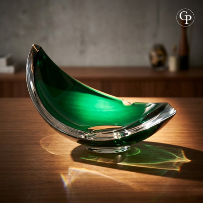 Vide-poche en cristal vert émeraude Val Saint Lambert sur une table en bois avec reflets lumineux | Emerald green crystal Val Saint Lambert bowl on a wooden table with striking light reflections